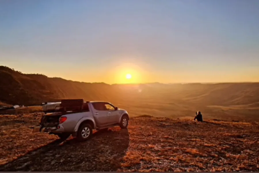 Pôr do sol no alto da chapada, com a Triton e a barraca de teto